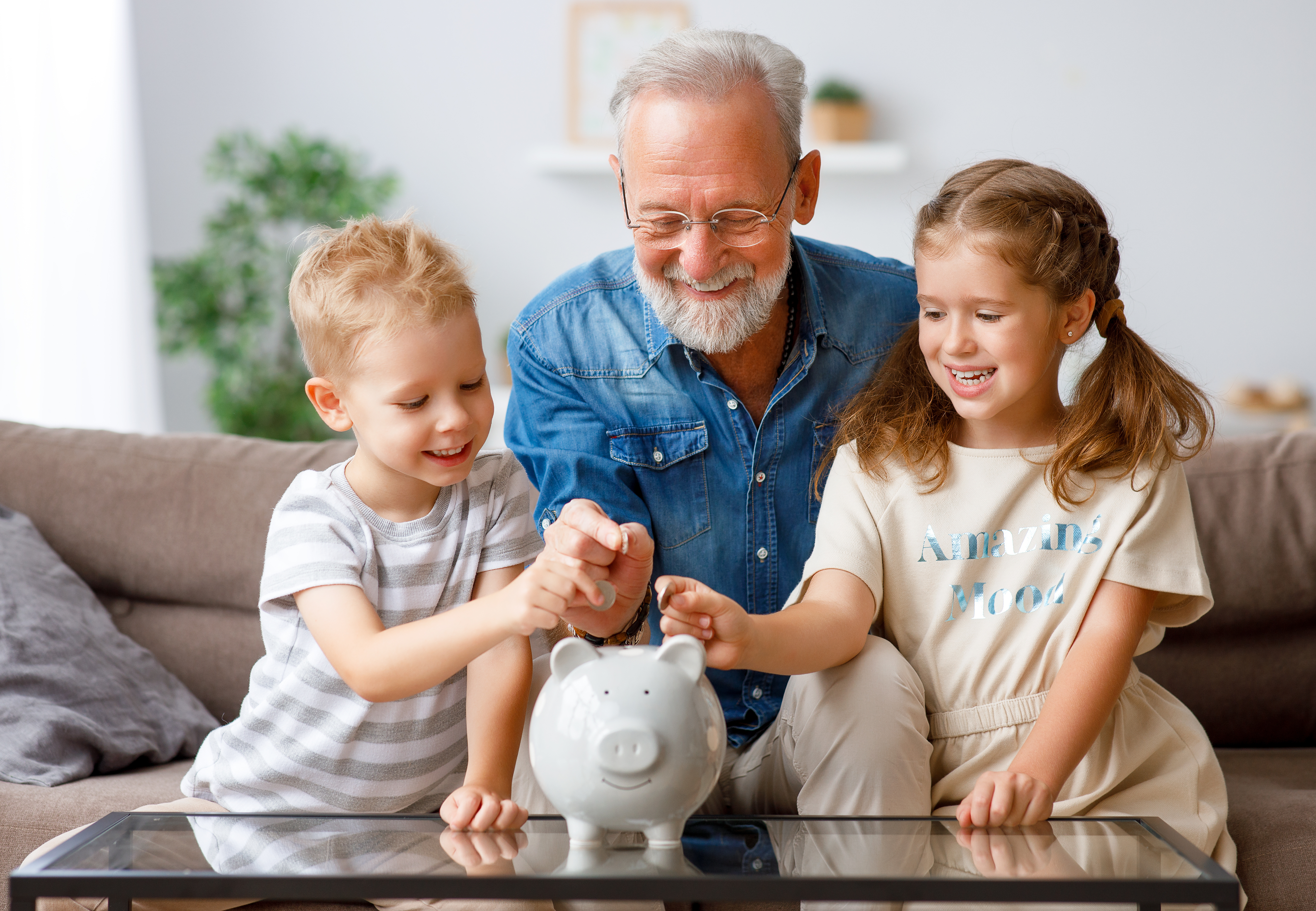 grandpa and kids putting money in piggy bank